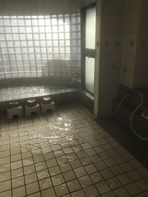 A bathroom with a tiled floor, a window with a grid pattern, and a handwashing station. - Business hotel route9 (Matsue)