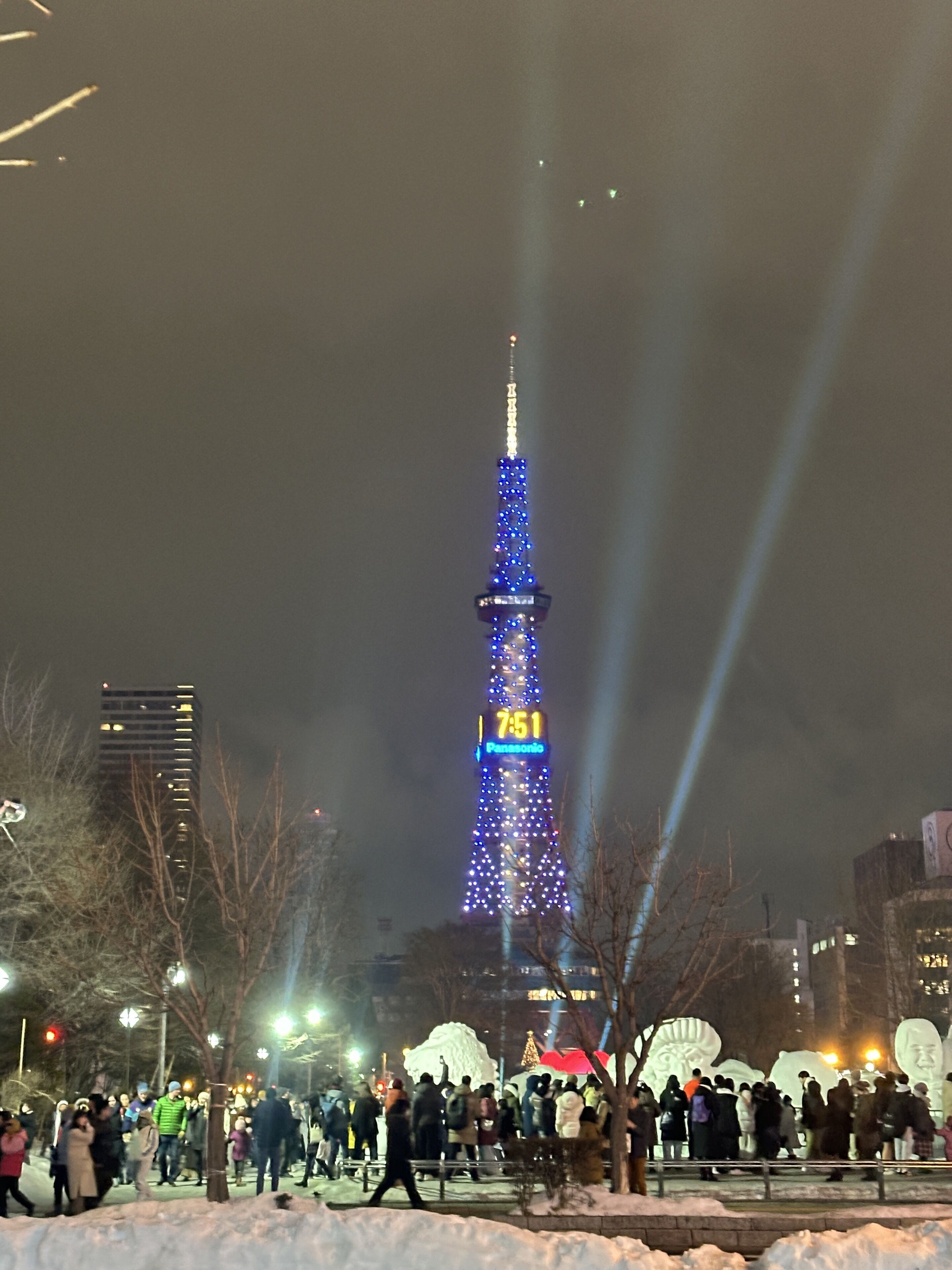 A tall tower with illuminated blue lights and a digital clock displaying 7:51.
