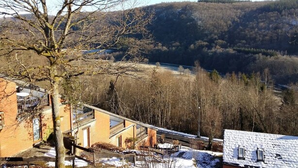 Un quartier résidentiel offrant une vue sur une rivière et des collines boisées.