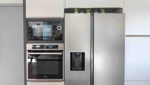 A modern kitchen with a built-in oven, a stainless steel refrigerator, and a black countertop. - Villa with 132 m2 of living space large living area large terrace and landscaped garden (Vias)