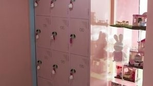 A room with a pink wall, a black and white checkered floor, and a cabinet with multiple compartments. - Fanhua (Seoul)