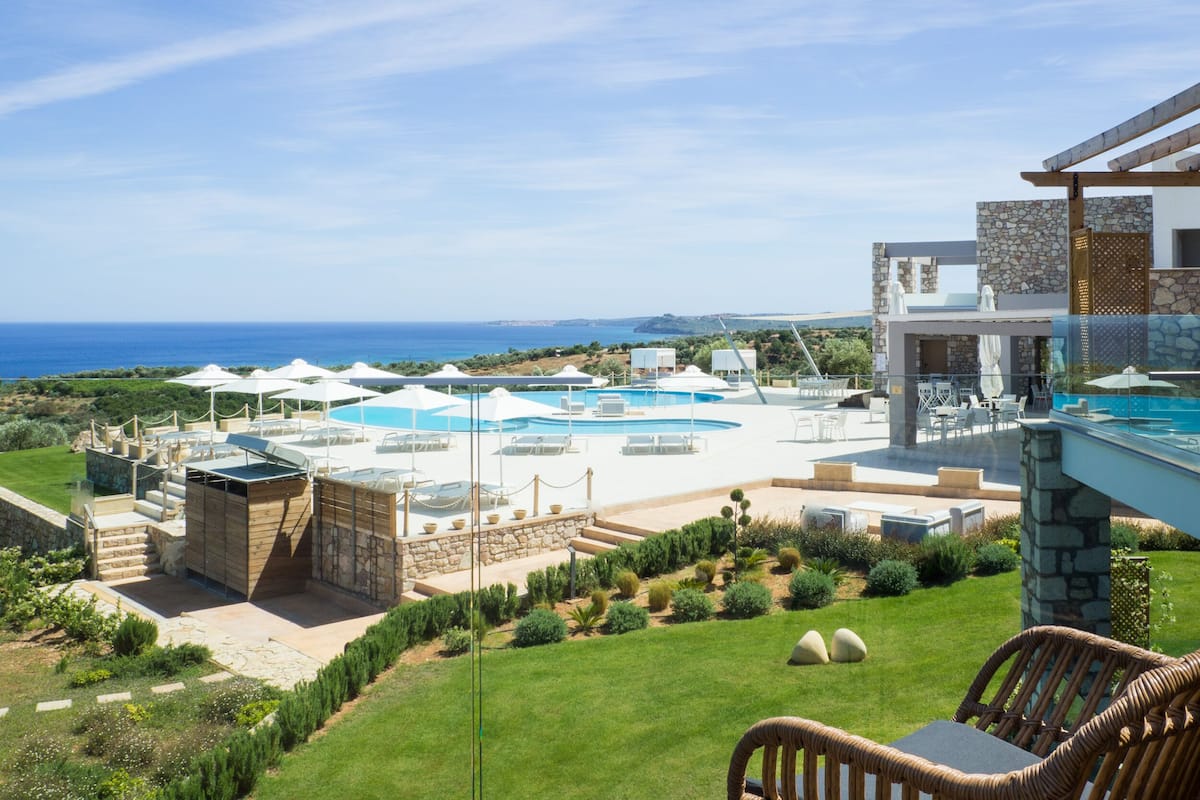 Un complexe hôtelier doté d’une piscine, d’un espace extérieur aménagé et offrant une vue sur la mer.