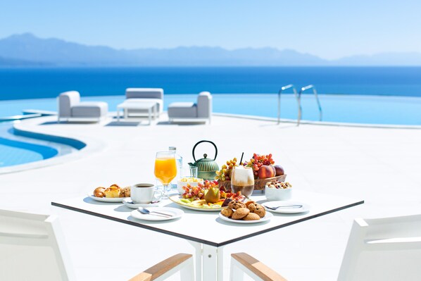 Una mesa de desayuno con vistas al océano y a las montañas.