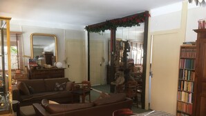 Ein gemütliches Wohnzimmer mit einer Couch, Sesseln, einem Couchtisch und einem Bücherregal.