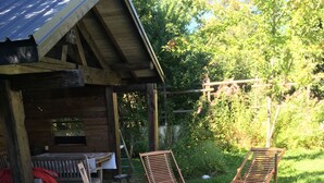 Eine Holzhütte mit einem steinbelagten Weg, der zu einer Holterrasse führt.