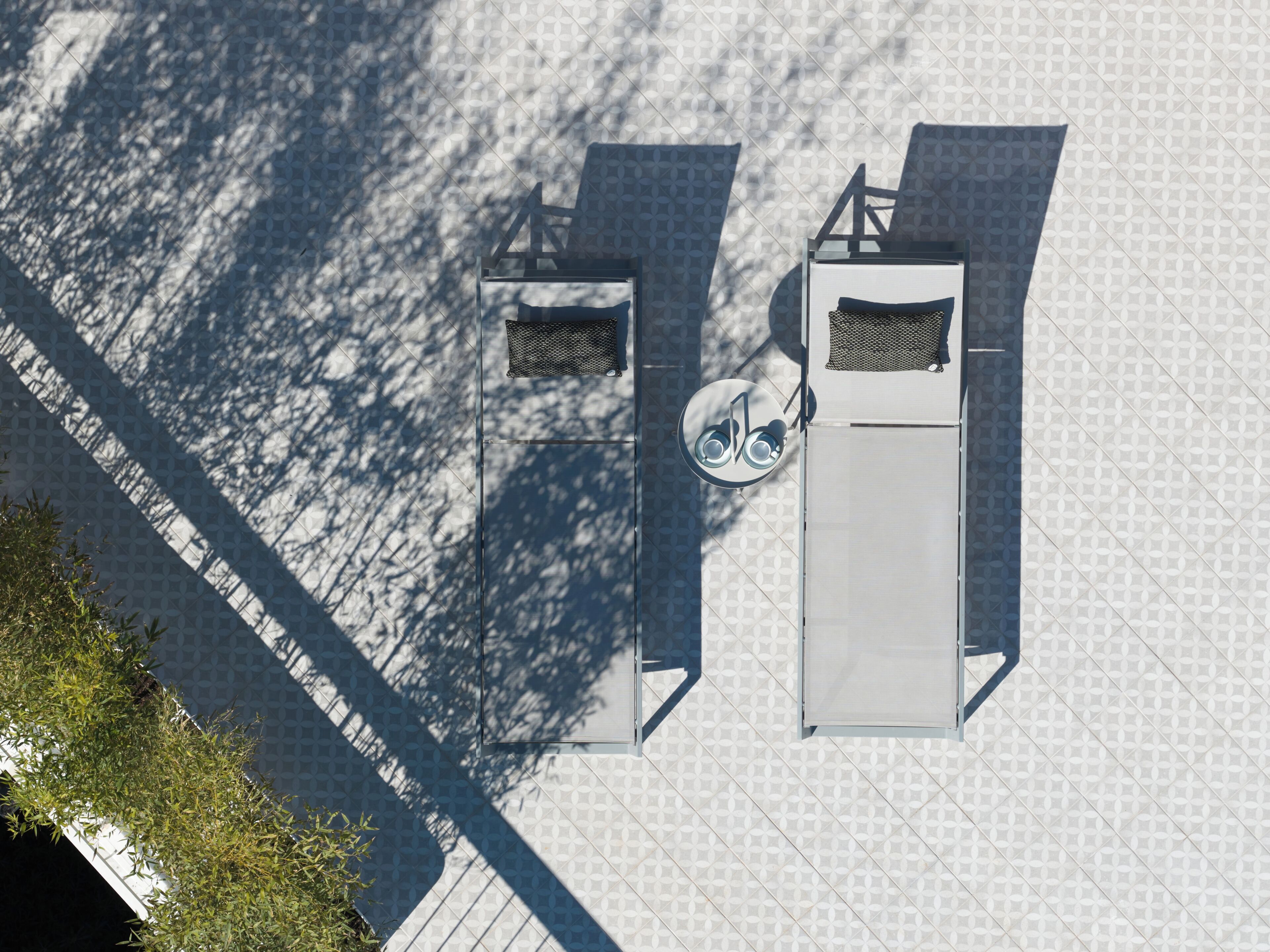 Een hoog hoekig uitzicht op een modern gebouw met vloerbedekking met geometrische patronen, een fietsenstalling en een metalen constructie met een fiets symbool.
