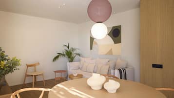 Um quarto moderno e bem iluminado, com uma mesa redonda, cadeiras, um sofá e um grande quadro abstrato na parede.