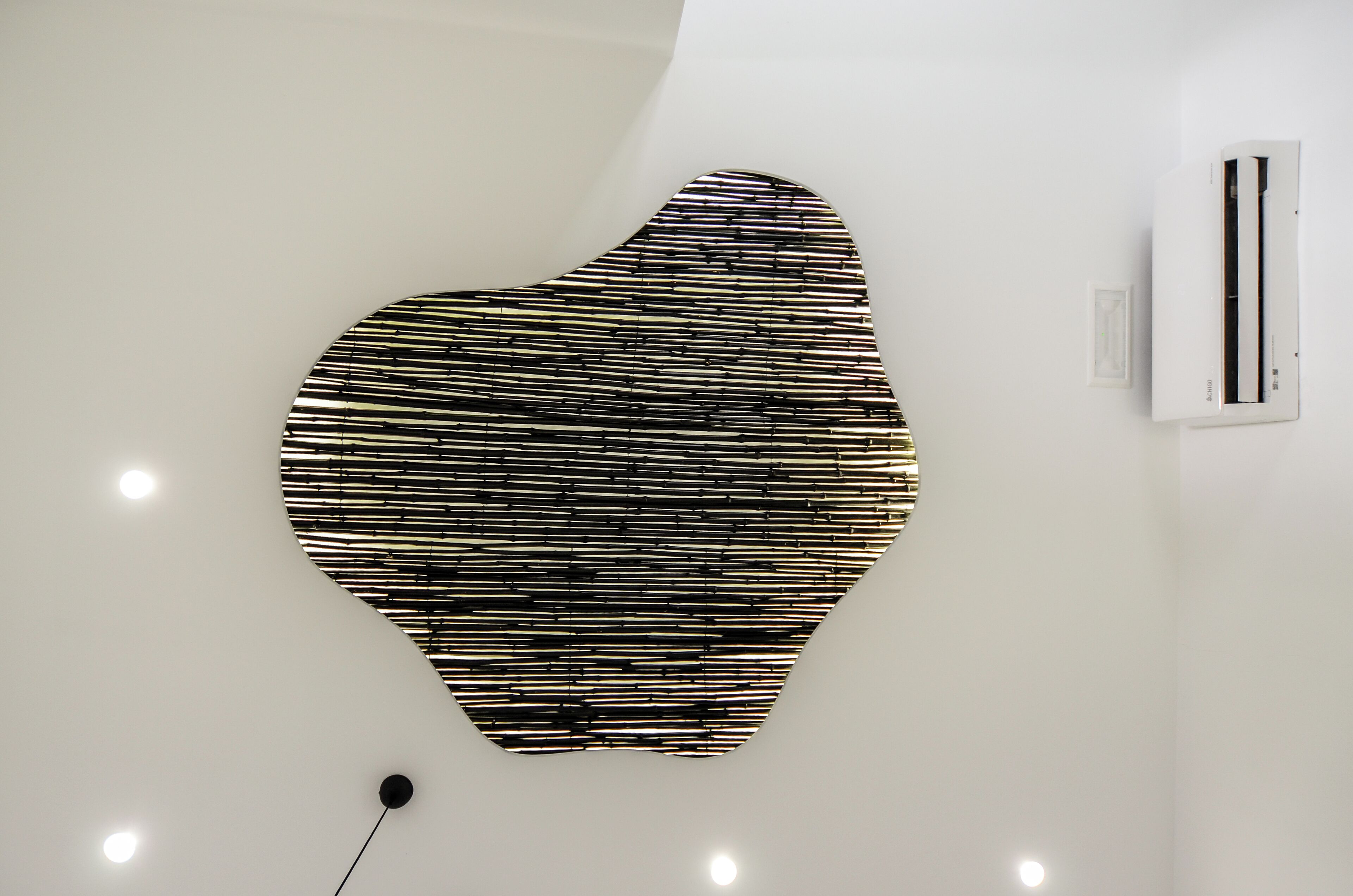 A modern interior with a unique wall art installation and a white air conditioning unit.
