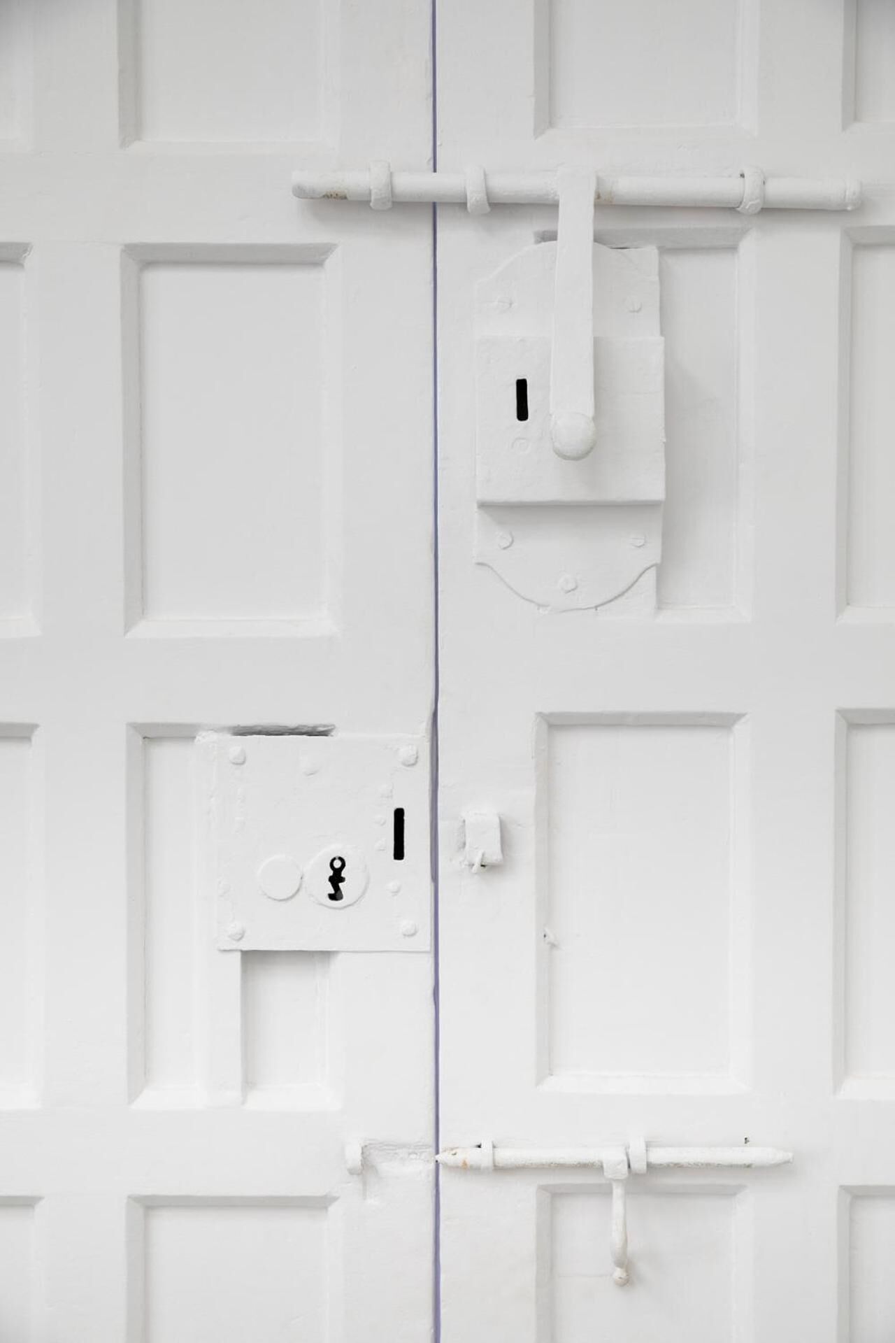 Una puerta blanca con cerradura y ojo de cerradura.