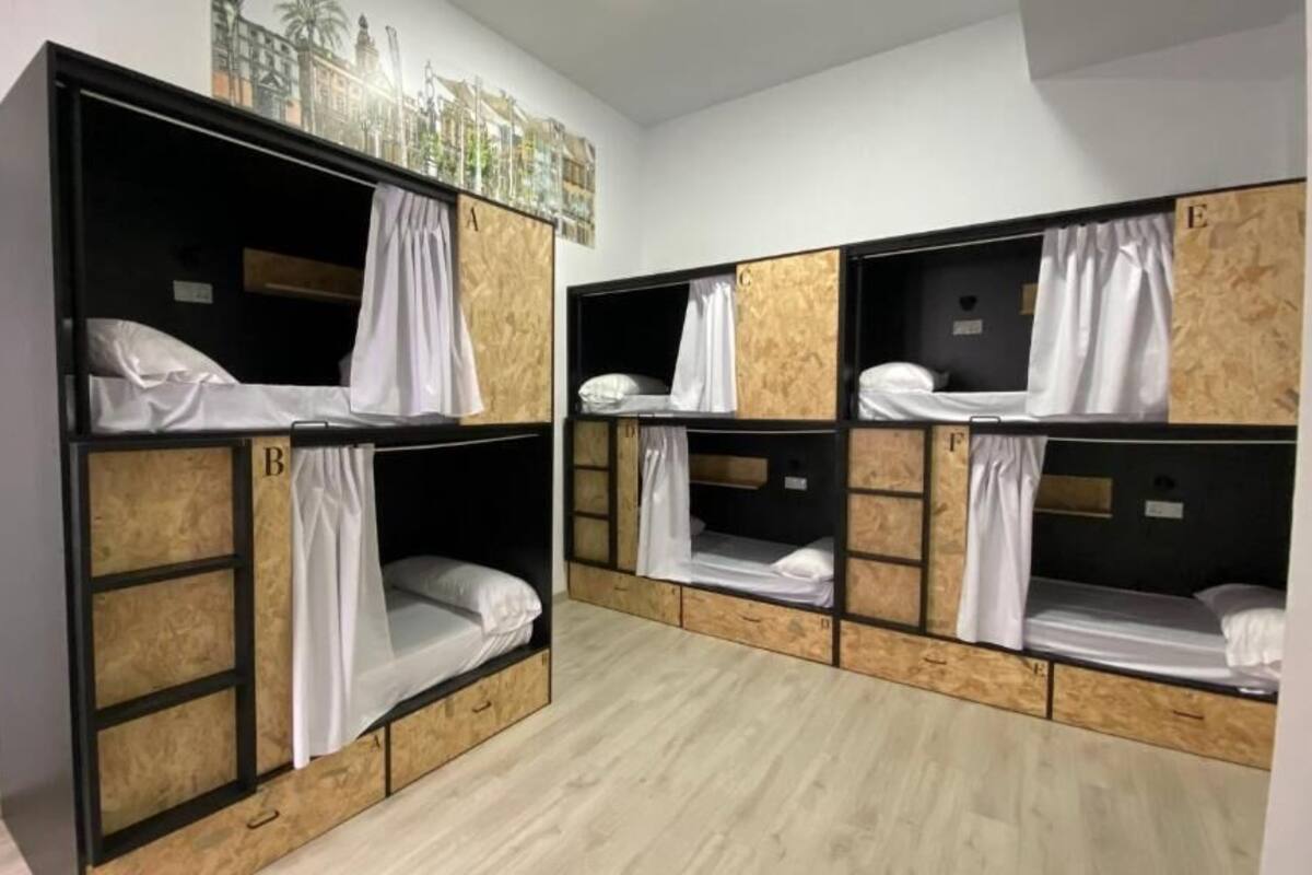 A room with bunk beds labeled A, B, C, D, E, and F, arranged in two rows.