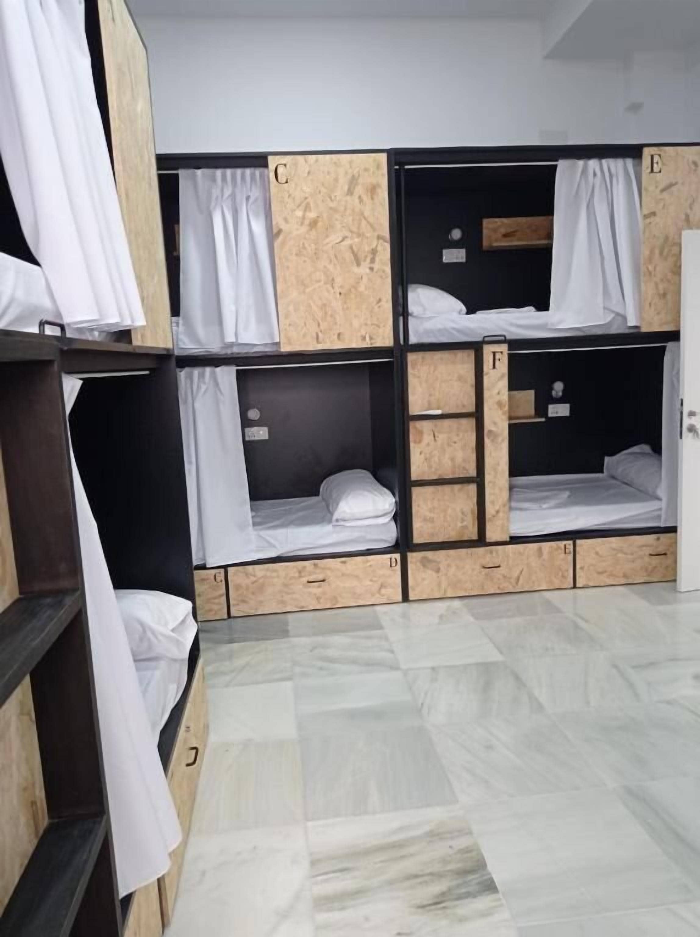 Un dormitorio tipo residencia con literas identificadas con las letras C, D, E y F.