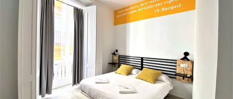 A modern bedroom with a bed, two pillows, a nightstand, and a wall-mounted lamp.