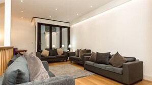 A modern living room with two sofas, a coffee table, and a large mirror. - Gorgeous house in the heart of Chelsea (London)