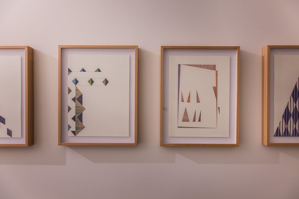 Quatre œuvres d’art encadrées sont accrochées au mur.
