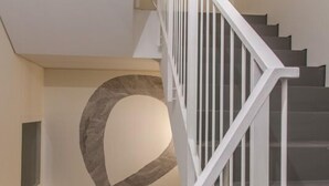 A staircase with white railings and a geometric wall design. - The Art Porto (Porto)