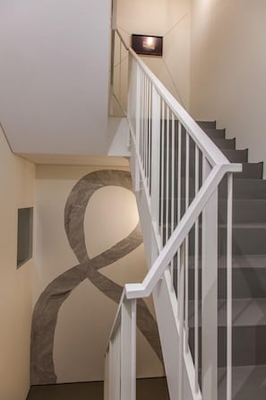 A staircase with white railings and a geometric wall design. - The Art Porto (Porto)