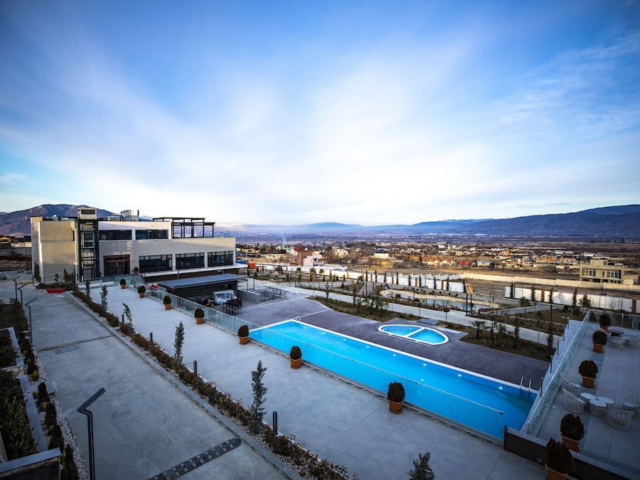 Una piscina techada, una piscina al aire libre de temporada, sombrillas