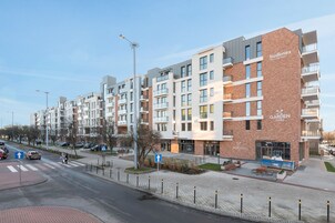 Un edificio de varios pisos con una combinación de fachada de ladrillo y moderna, que cuenta con balcones y ventanas amplias.