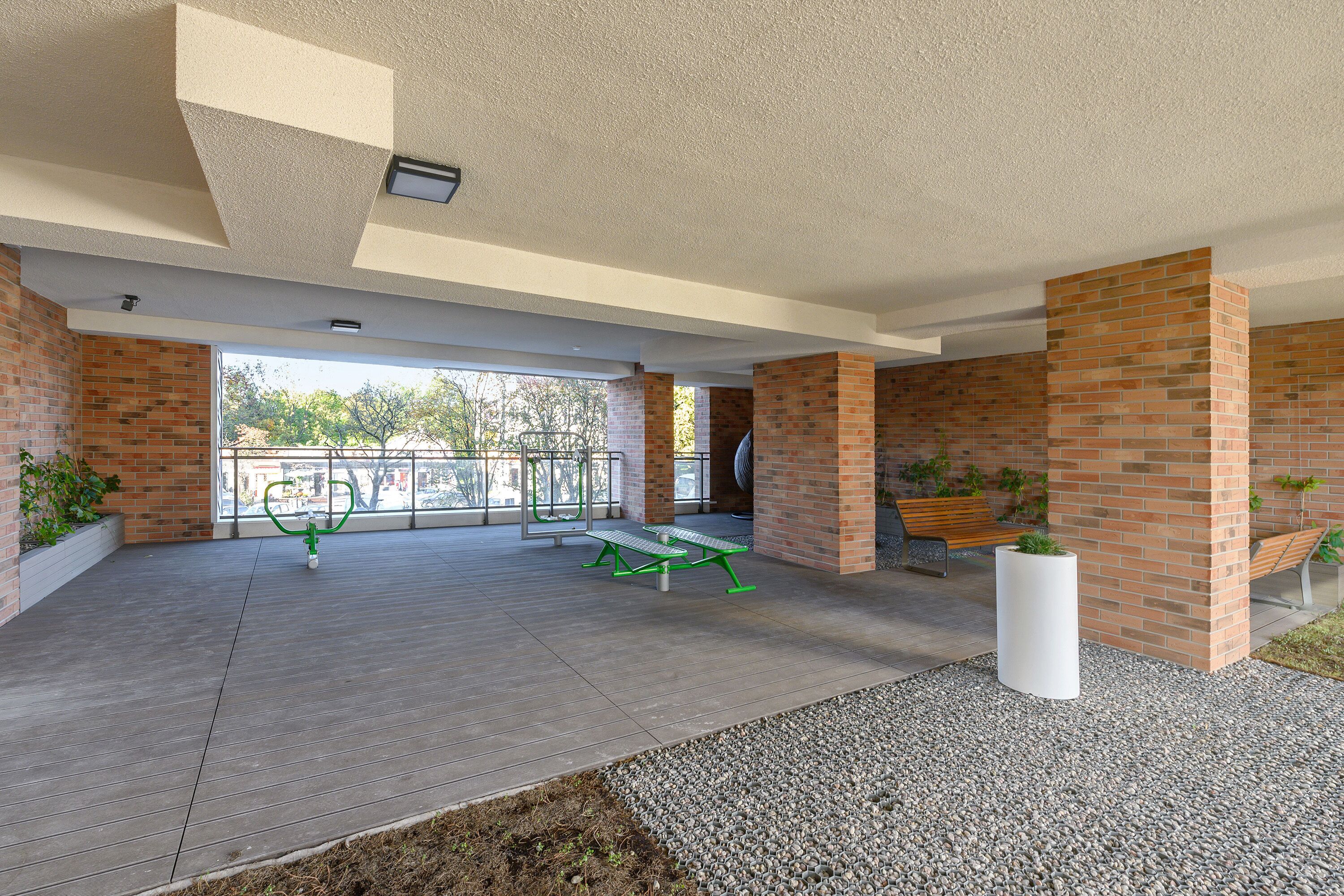 An outdoor patio area with brick walls, a wooden deck, and a white planter.