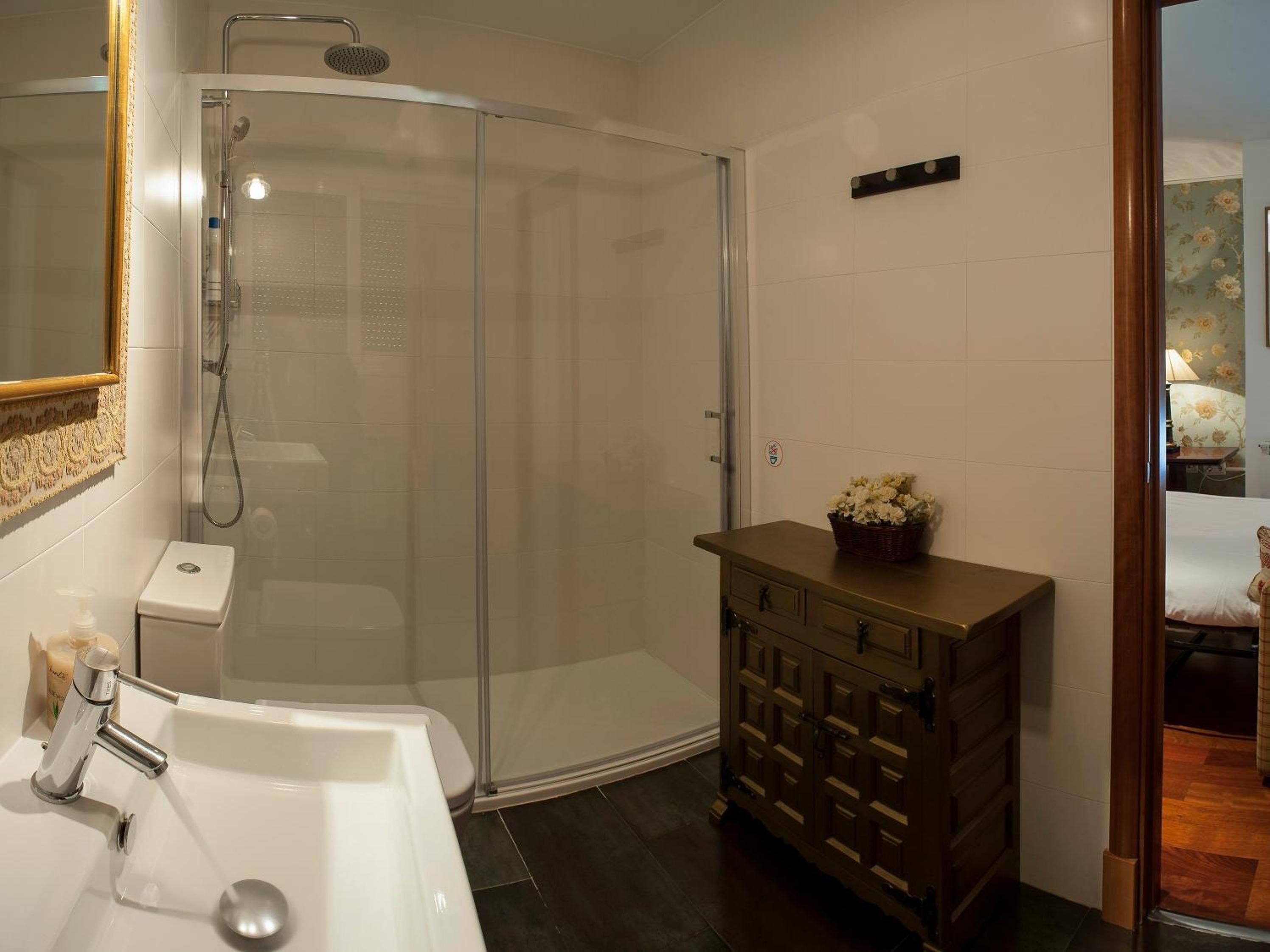 A bathroom with a shower, a sink, and a vanity with drawers.