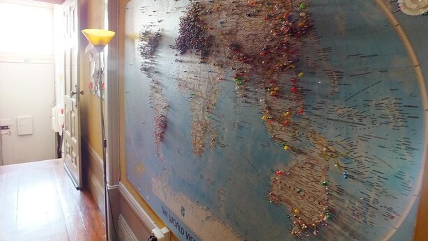 A large world map with pins and a lamp. - Oporto Sky Hostel (Porto)