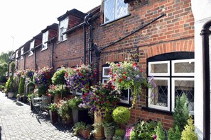 A row of brick buildings with flower boxes on the windowsills. - Luxury Cottage Near Windsor Castle (Windsor)
