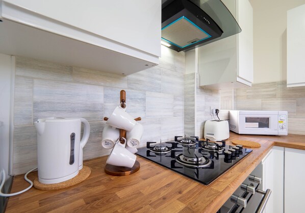 Departamento Confort | Cocina privada | Refrigerador, microondas, horno y parrilla de estufa