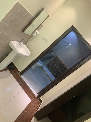 Une salle de bain avec un lavabo, un miroir et une fenêtre.