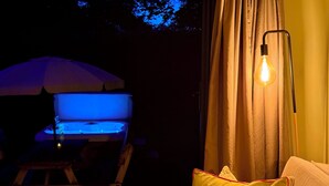 A dimly lit room with a wooden chair, a yellow pillow, and a table with a blue-lit object.