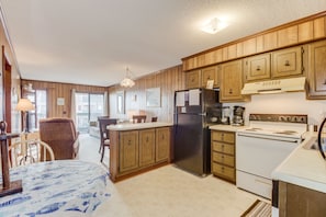 Enjoy cooking in this well-equipped kitchen with a central island, refrigerator, stove, and coffee maker.