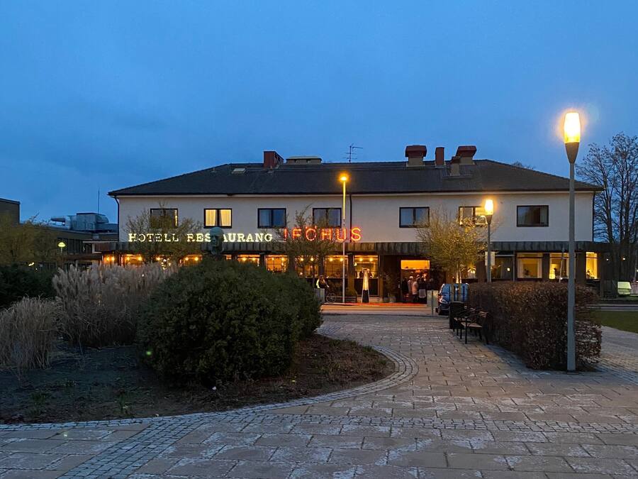 A hotel with a restaurant named "HOTEL RESORT IFOHUS" and a well-lit entrance.