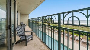 A balcony with chairs and a view of the beach. - Spacious 1st floor corner Oceanfront unit + Free Attraction Tickets! (North Myrtle Beach)