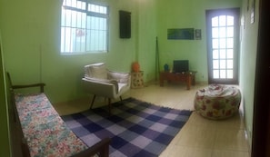 Ein Zimmer mit einem Bett, einem Sofa, einem Fernseher und einem Fenster.