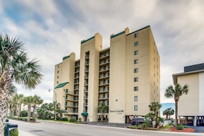 A multi-story hotel with a beige facade, balconies, and a sign reading "Beach Club III".
