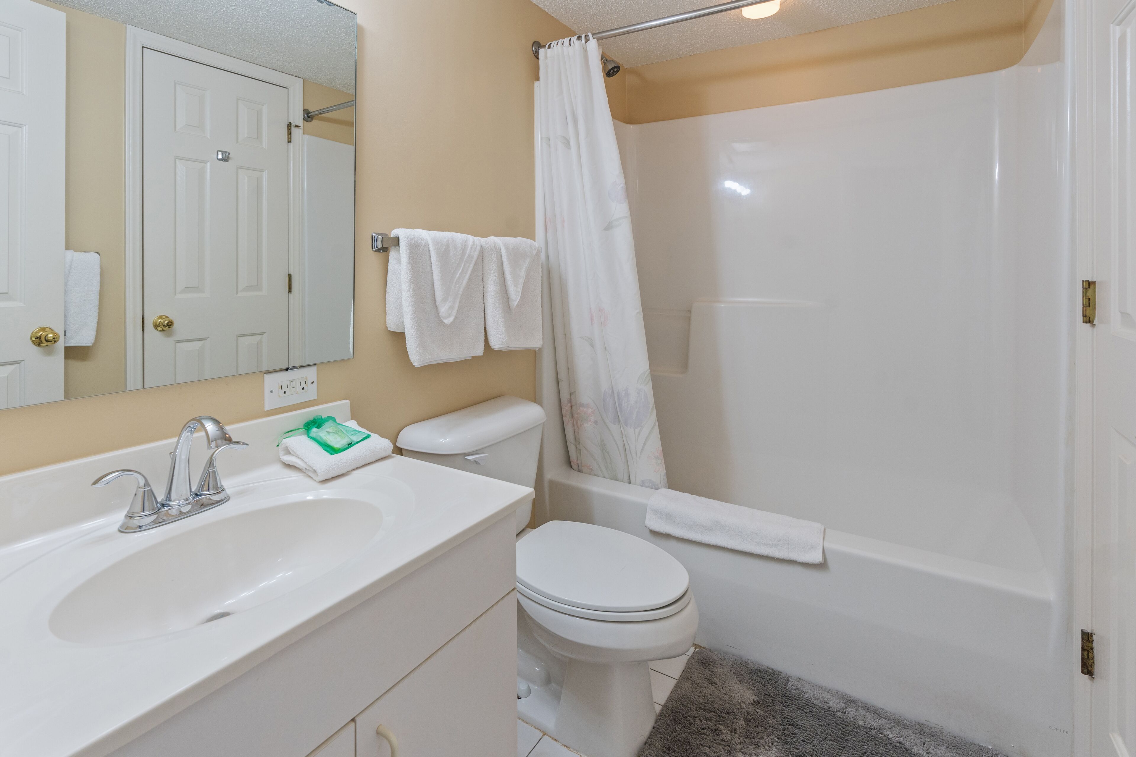 Un baño con lavamanos, inodoro y bañera blancos.