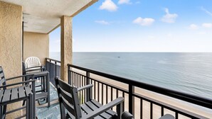 Un balcon avec vue sur l’océan, comprenant une table et des chaises.
