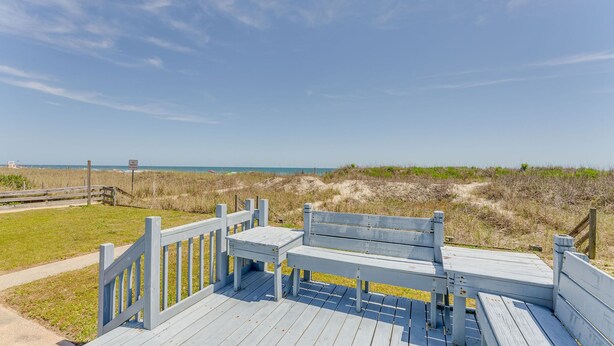 A wooden boardwalk leading to a beach with a bench and a fence. - Pet Friendly Oceanfront Duplex (bottom floor) + Free Attraction Tickets! (North Myrtle Beach)