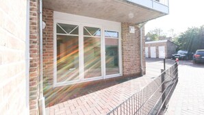 A building with a brick facade, large windows, and a balcony. - Well-kept apartment in Greetsiel (Greetsiel)