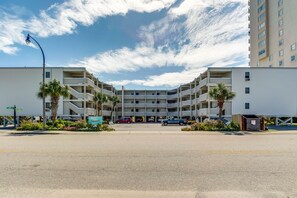 A multi-story parking garage with a central open area, surrounded by buildings with balconies and a clear sky. - Newly updated Ocean View unit + Free Attraction Tickets! (North Myrtle Beach)