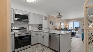 A modern kitchen with stainless steel appliances, a dishwasher, and a large island.