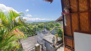 A traditional wooden building with a balcony overlooking a lush landscape. - Ramp Cottage (Penida Island)