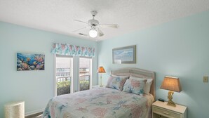A bedroom with a bed, nightstands, a ceiling fan, and a window with a view. - Pet Friendly Newly Updated Home + Free Attraction Tickets! (North Myrtle Beach)