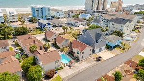 A residential area with houses, a swimming pool, and a beach in the background. - Pet Friendly Newly Updated Home + Free Attraction Tickets! (North Myrtle Beach)