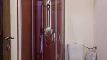 Une salle de bain moderne avec une douche à parois de verre, des toilettes blanches et un plancher en bois.