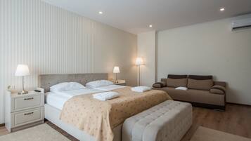 Una camera da letto moderna con un letto grande, comodini, un divano e una panca.