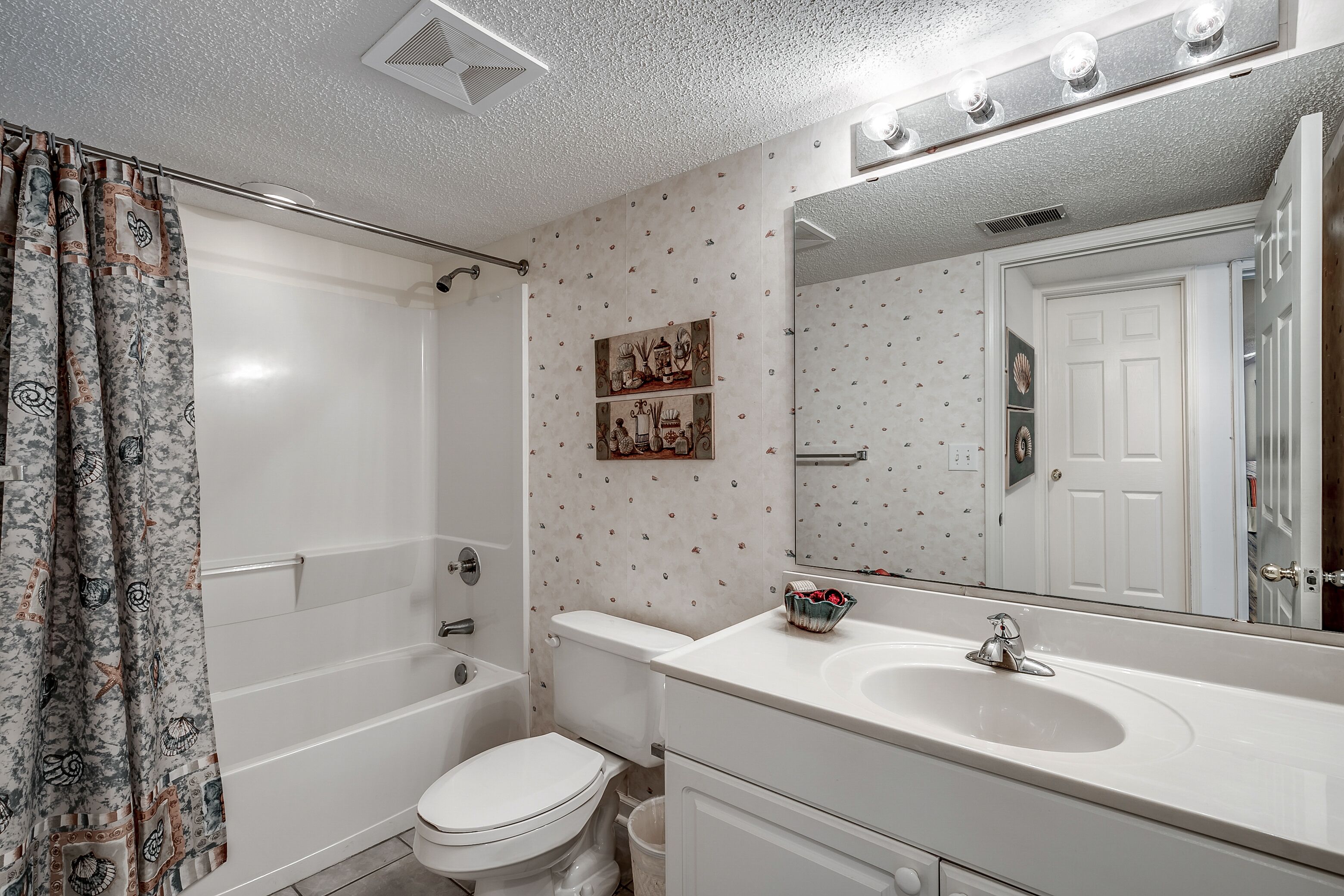 Een badkamer met een bad, toilet en wastafel.