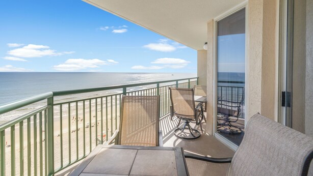 Ein Balkon mit Blick auf den Strand und den Ozean.