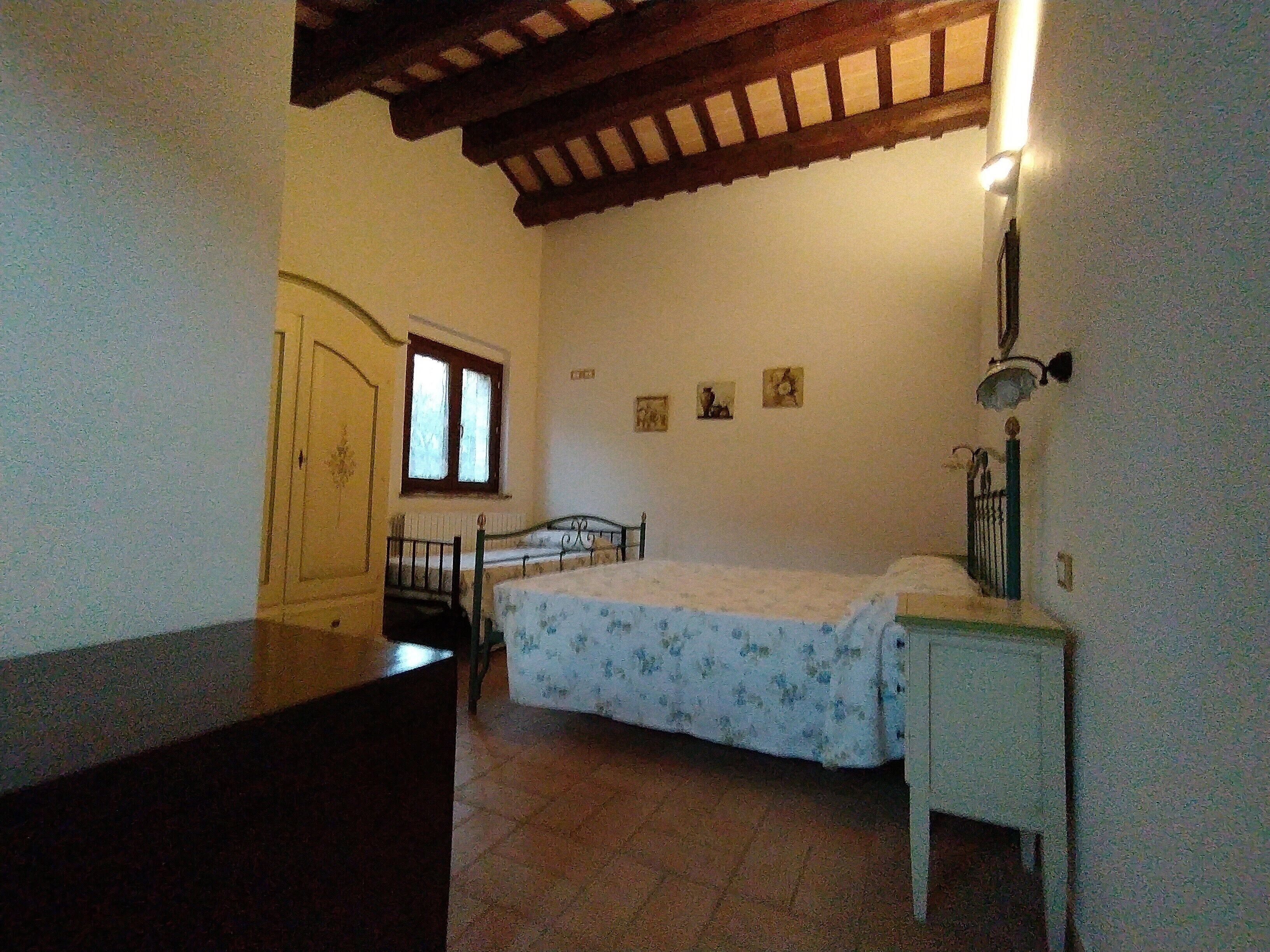 Una camera da letto con un letto, una scrivania, una sedia, un armadio e una finestra.