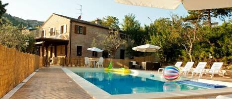 Een seizoensgebonden buitenzwembad en parasols bij het zwembad