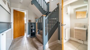 A staircase with a wooden door at the top, a white radiator, and a small shelf with items. - Seashells (2), Wells-next-the-Sea, Norfolk (Wells-next-the-Sea)